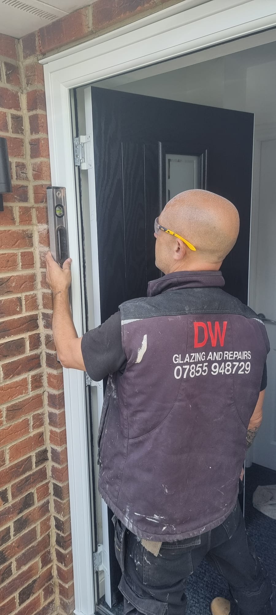 David Webb of DW Glazing and Repairs levelling a newly fitted composite door frame in Hartlepool